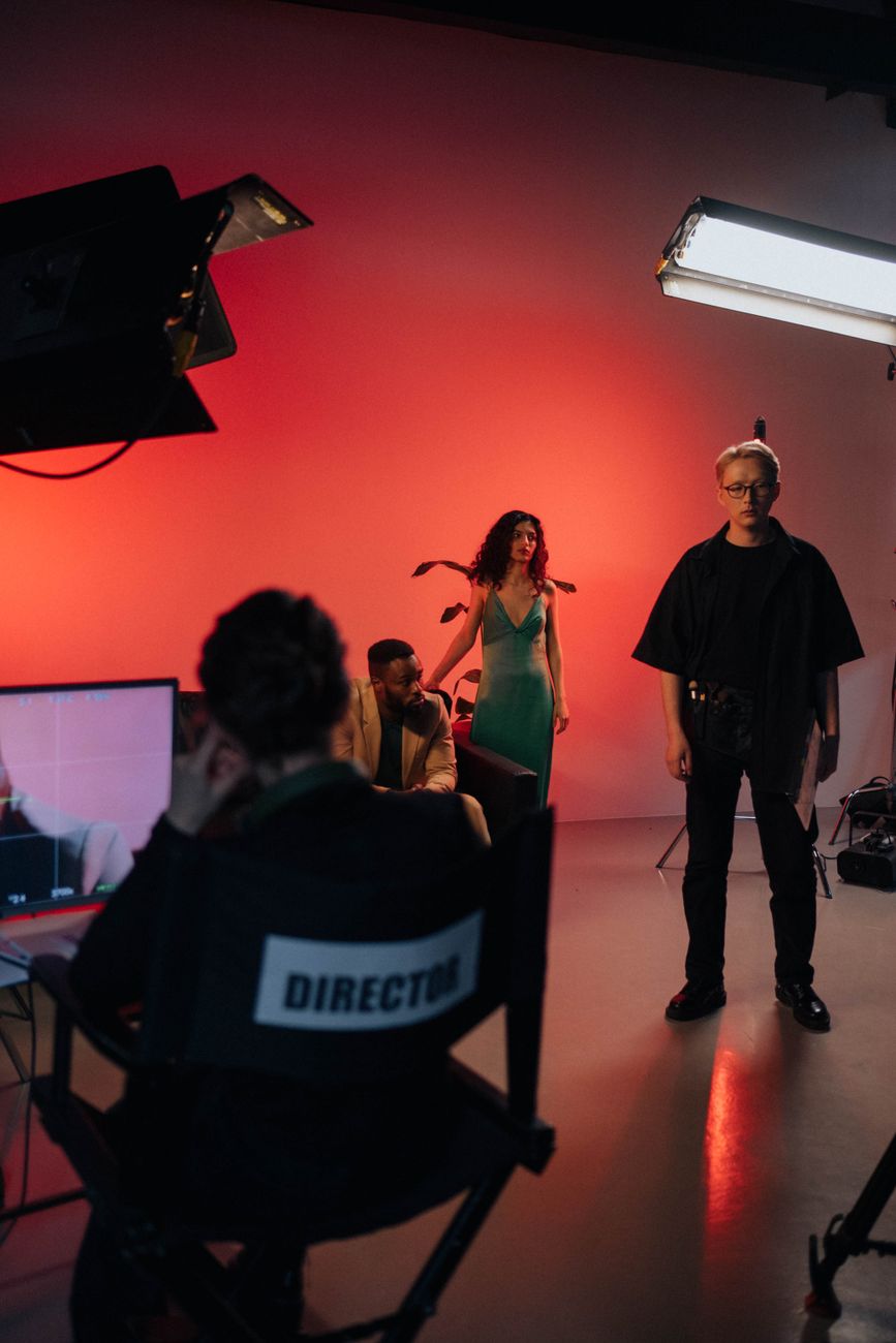 TV production crew filming in a modern studio with giant screens