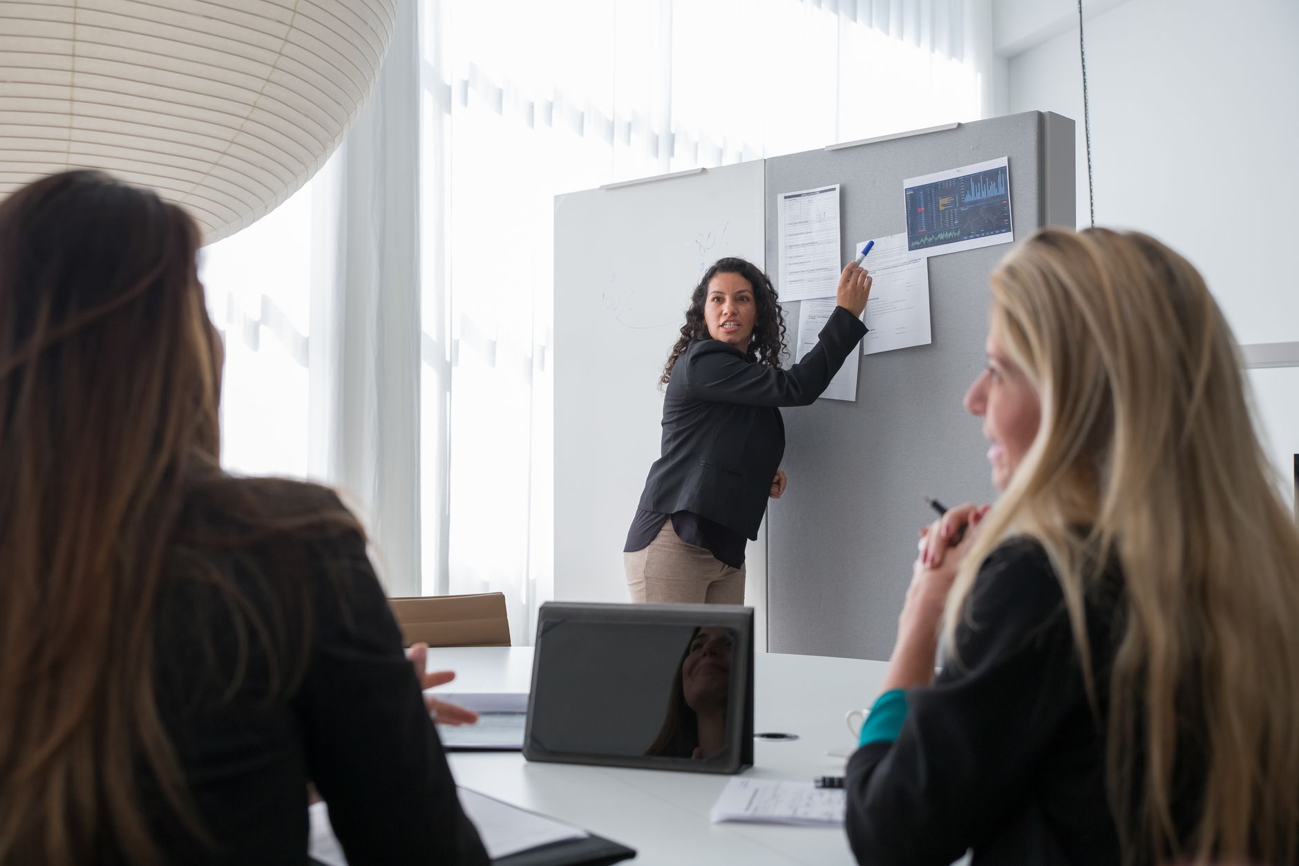 Executive presenting data analytics on a board in meeting room
